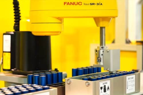 fanuc yellow robot packaging batteries