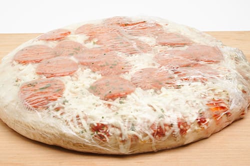 A shrink-wrapped frozen pizza