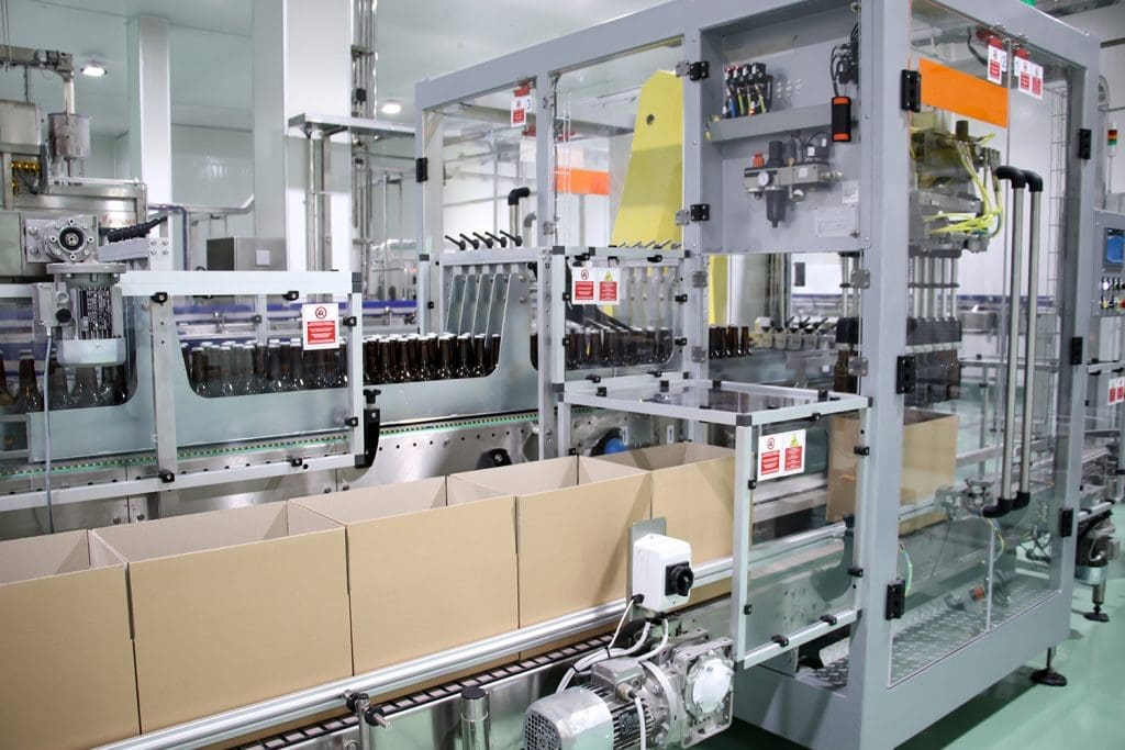 A case-forming machine placing beer bottles into cases.