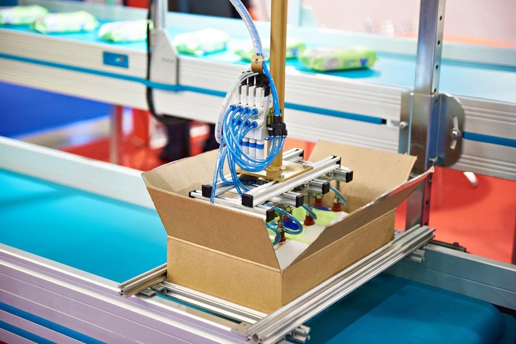 An automated system placing items into a box.