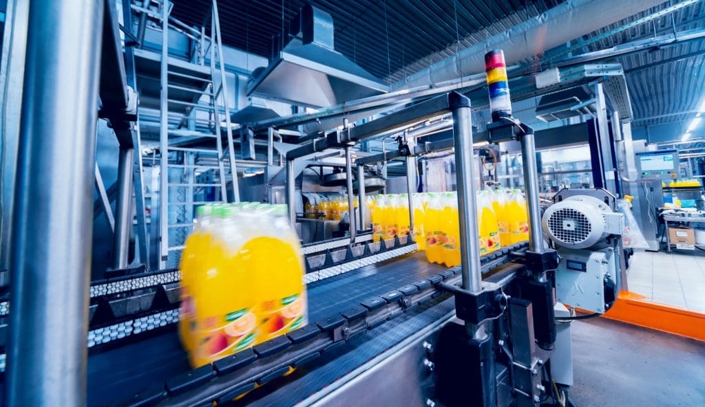 Packaged juices flying by on a conveyor belt.